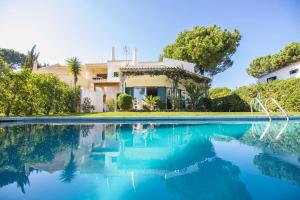 a villa with a swimming pool in front of a house at Casa Clara in Vilamoura
