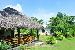 a hut with a straw roof and a table and chairs at Sea sound cabana & Restaurant in Tangalle