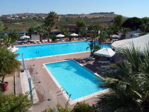 a large swimming pool with blue water in a resort at Kamemi Village & Camping in Ribera