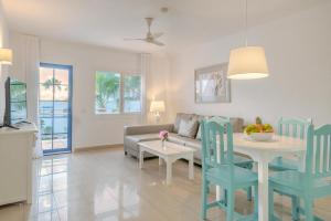 a living room with a couch and a table and chairs at Apartamentos Parque Tropical en Lanzarote in Puerto del Carmen