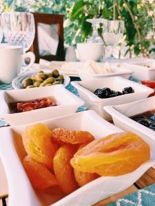 a table topped with white dishes filled with food at Kybele Hotel Gocek in Göcek
