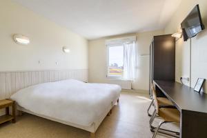 a hotel room with a bed and a desk and a television at Azureva Métabief in Métabief