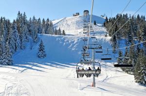 a group of people riding a ski lift in the snow at Azureva Métabief in Métabief