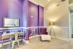 Habitación púrpura con escritorio y silla en Ruby Room, en Chicago
