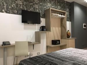 1 dormitorio con 1 cama y TV en la pared en Hotel Centrale en Siracusa