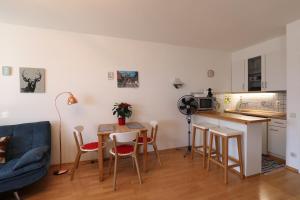 eine Küche und ein Wohnzimmer mit einem Tisch und Stühlen in der Unterkunft Mountain Home Garmisch in Garmisch-Partenkirchen