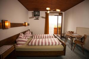 Schlafzimmer mit einem Bett, einem Tisch und einem Fenster in der Unterkunft Ferienpension Garni Hubert Rigelnik in Sankt Kanzian am Klopeiner See