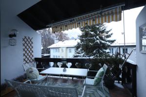 ein Tisch und Stühle auf einem Balkon mit einem Weihnachtsbaum in der Unterkunft Mountain Home Garmisch in Garmisch-Partenkirchen