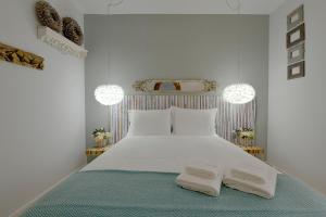 リスボンにあるRegedorのベッドルーム1室(白いベッド1台、タオル2枚付)