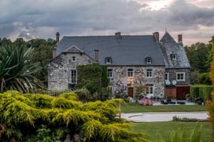 an old stone house with a large yard at Le Richmond in Godinne