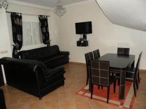 uma sala de estar com uma mesa e cadeiras pretas e um sofá em Villa El Andalousse em Larache