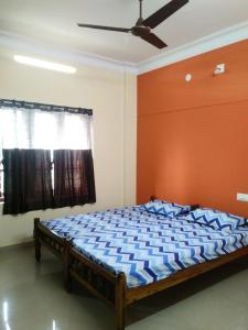 a bedroom with a bed with an orange wall at Sowparnika N.V Nagar Peroorkada in Trivandrum