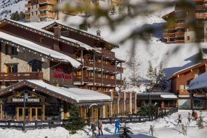 domek narciarski na śniegu obok stoku narciarskiego w obiekcie Hotel Mont Vallon w Méribel