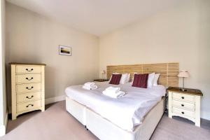 una camera da letto con un grande letto bianco e due comodini di JOIVY Great Location - Lovely Rose St Apt in City Centre a Edimburgo