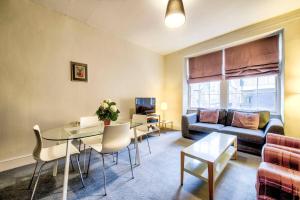 a living room with a table and a couch at JOIVY Perfect Location! - Stylish & Cosy Rose St Apt in Edinburgh