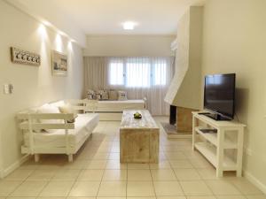 a living room with a couch and a tv at Atlántico Boutique Hotel in Punta del Este