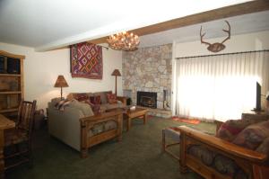 een woonkamer met een bank en een open haard bij Snowcreek Resort Vacation Rentals in Mammoth Lakes