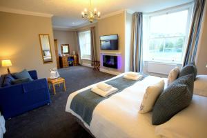 a bedroom with a large bed and a living room at Brathay Lodge in Ambleside