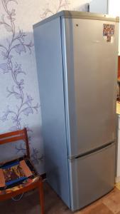 ケメロヴォにある128 проспект Ленина Комната гостиничного типаの冷蔵庫付きのキッチン(椅子付)