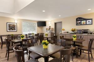 un restaurante con mesas y sillas con flores. en Days Inn by Wyndham Ottawa Airport en Ottawa