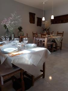 une salle à manger avec une table, des assiettes et des verres à vin dans l'établissement Casa Sastre, à Espúy