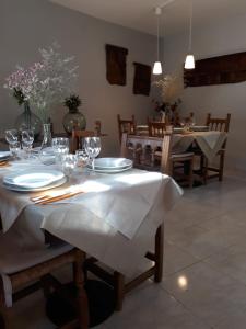 un comedor con una mesa con platos y copas de vino en Casa Sastre, en Espúy