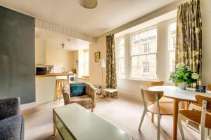 a living room with a table and chairs at ALTIDO Amazing Location! - Lovely Rose St Apt in New Town in Edinburgh