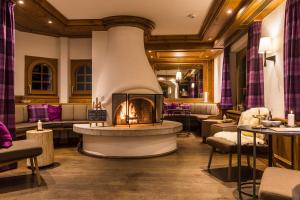 a restaurant with a fireplace in the middle of a room at Hotel Bella Vista Zermatt in Zermatt