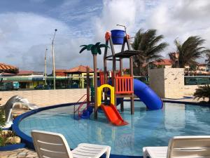 a swimming pool with a playground in a resort at Hotel Concha do Mar in Salinópolis