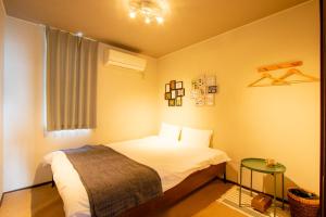 a small bedroom with a bed and a table at SLOW HOUSE NARA in Nara