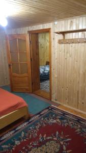 Cette petite chambre comprend un lit et un miroir. dans l'établissement Базилік Люкс, à Yaremtche