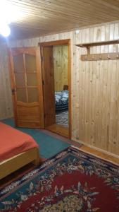 Una pequeña habitación con una cama y un espejo. en Базилік Люкс, en Yaremche