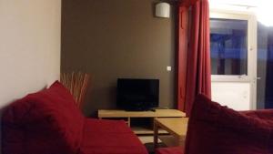 リュス・サン・ソヴァールにあるT3 rénové Luz Centreのリビングルーム(赤いソファ、テレビ付)
