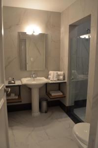 y baño con lavabo, espejo y ducha. en Hotel Plaza Revolución en Ciudad de México