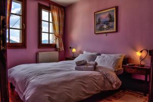 una camera da letto con un grande letto con pareti viola di Dio Studios ad Aráchova