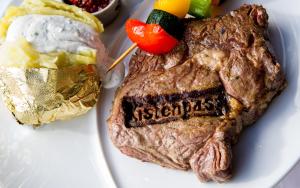 ein Steak auf einem Teller mit Kartoffelbrei und Gemüse in der Unterkunft Hotel Kistenpass in Brigels