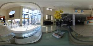 a lobby with a glass floor with a vase of yellow flowers at Hotel Piramide Pituba - Av Paulo VI in Salvador