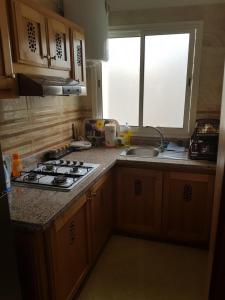 a kitchen with a stove and a sink and a window at Prestige appartement coeur du Rabat in Rabat
