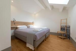 a bedroom with a bed with a wooden headboard at Bom-Jardim Trindade in Porto