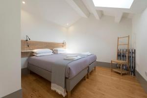 1 dormitorio con 1 cama con cabecero de madera en Bom-Jardim Trindade, en Oporto
