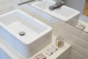 a bathroom with a white sink and a mirror at Bom-Jardim Trindade in Porto +7 photos
