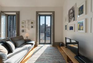 a living room with a couch and a television at Bom-Jardim Trindade in Porto