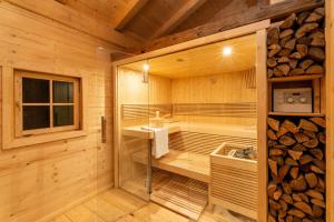 eine Sauna mit einer Badewanne, einem Waschbecken und einem Fenster in der Unterkunft Exklusives Alpenchalet in Bayrischzell