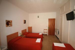 a hotel room with two beds and a television at Hostal Juventus in Portbou