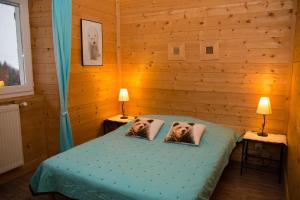 1 dormitorio con 1 cama con 2 fotos de perros en las almohadas en Gites L'épilobe, en Saint-Léger-les-Mélèzes