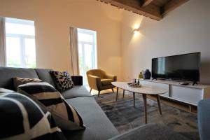 a living room with a couch and a tv at 1118 Lofts in Porto