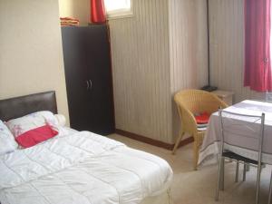 バニョール・ドゥ・ロルヌにあるRésidence Porquerolesのベッドルーム1室(ベッド1台、テーブル、椅子付)