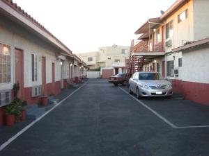 un'auto parcheggiata in un parcheggio accanto agli edifici di American Inn a South El Monte