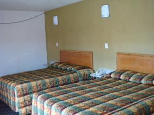 a hotel room with two beds in a room at American Inn in South El Monte