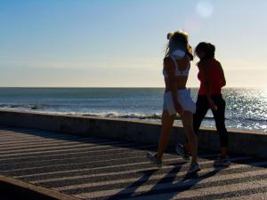 two girls walking along the beach near the ocean at Atlántico Boutique Hotel in Punta del Este